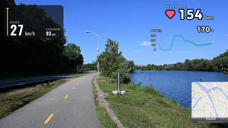 A photo of a riverside bike path under a blue sky; a data panel with speed (27 km/h) and cadence (93 rpm) top left, heart rate (154 bpm) with a heart and a power graph (170 W) top right, a small street map bottom right.